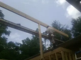 Carpenter setting a ridge beam over a new addition frame — Ice Dam Removal by Roofing Brothers in Talking Rock