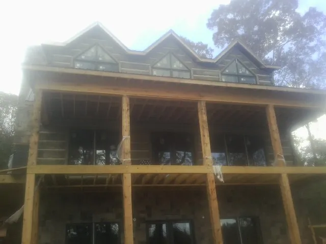 Dormers and porch framing on a large log home under construction — Roof Coating work by our crew in Talking Rock