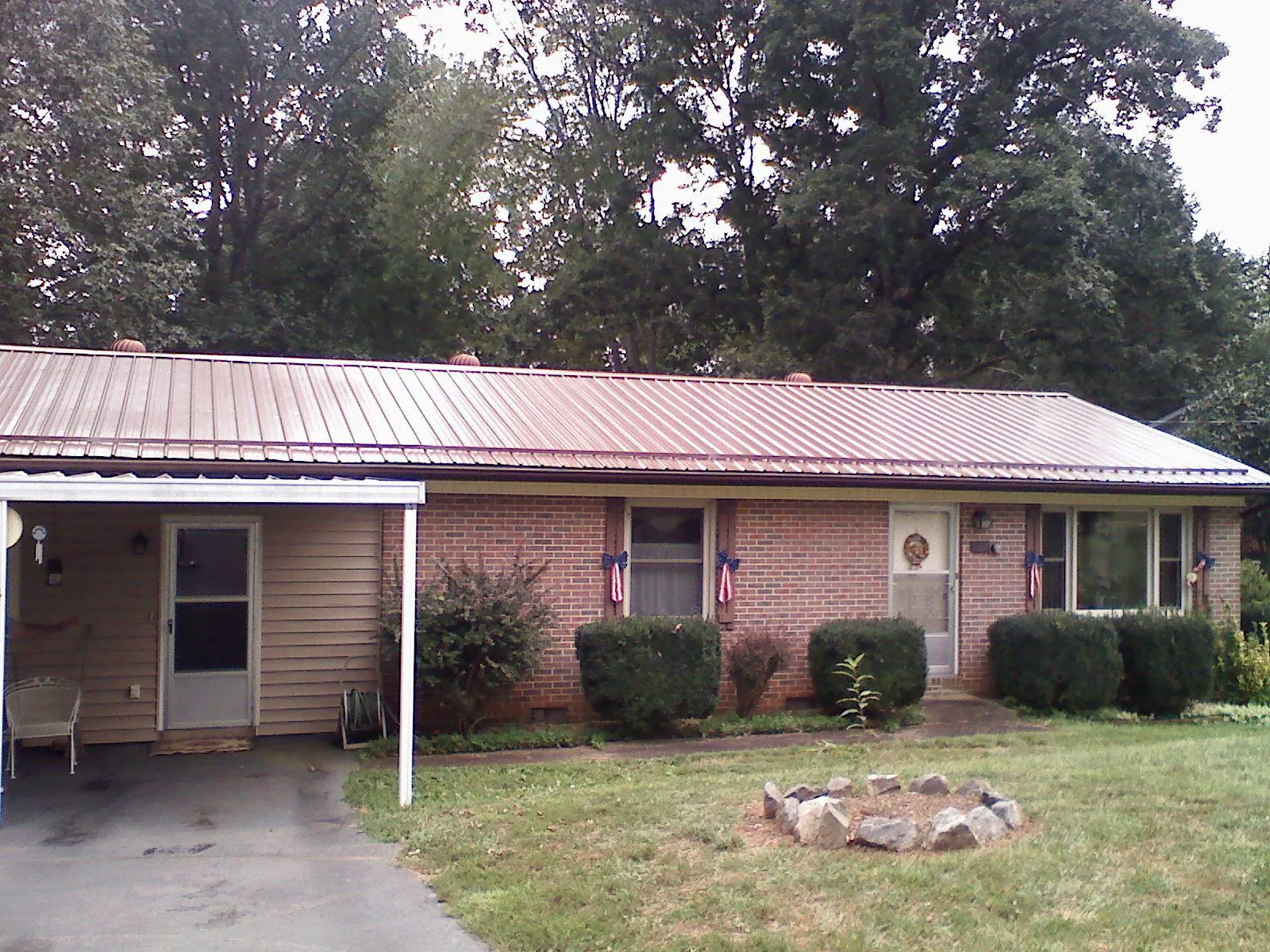 Bronze metal roof and carport on a brick ranch home — Roof Repair work by our crew in Talking Rock